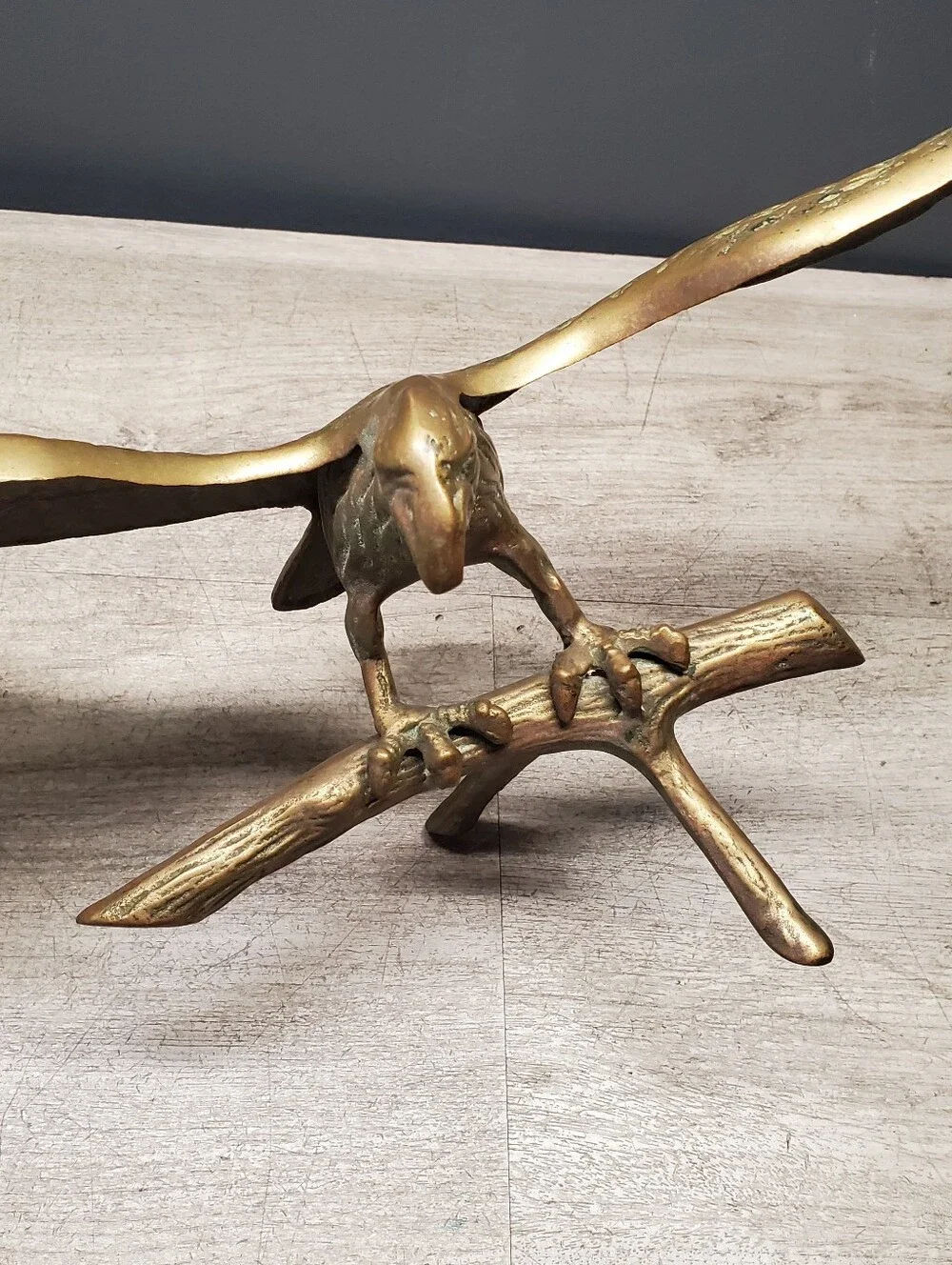 Vintage brass eagle statue perched on a tree branch